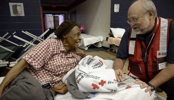 volunteer speaking with elder woman at shelter