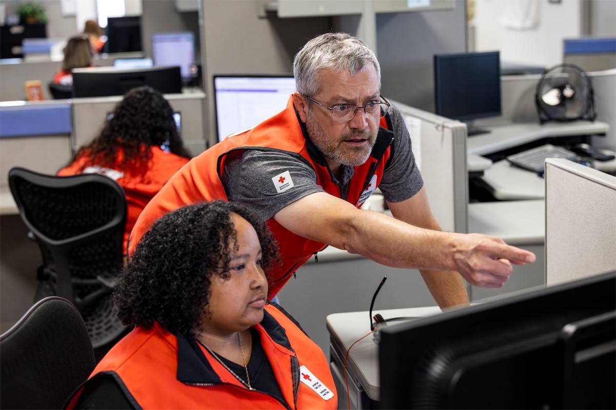Sean Day is helping a coworker with a case in the American Red Cross Hero Care Center.