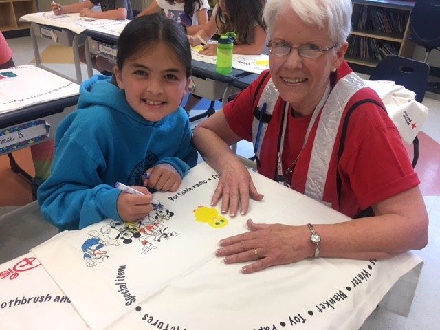 Red Cross volunteer working with young girl