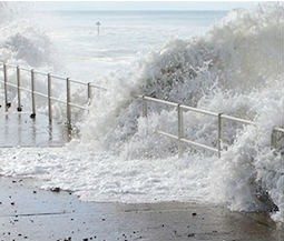 Violent waves overwhelming the safety barrier on a beach