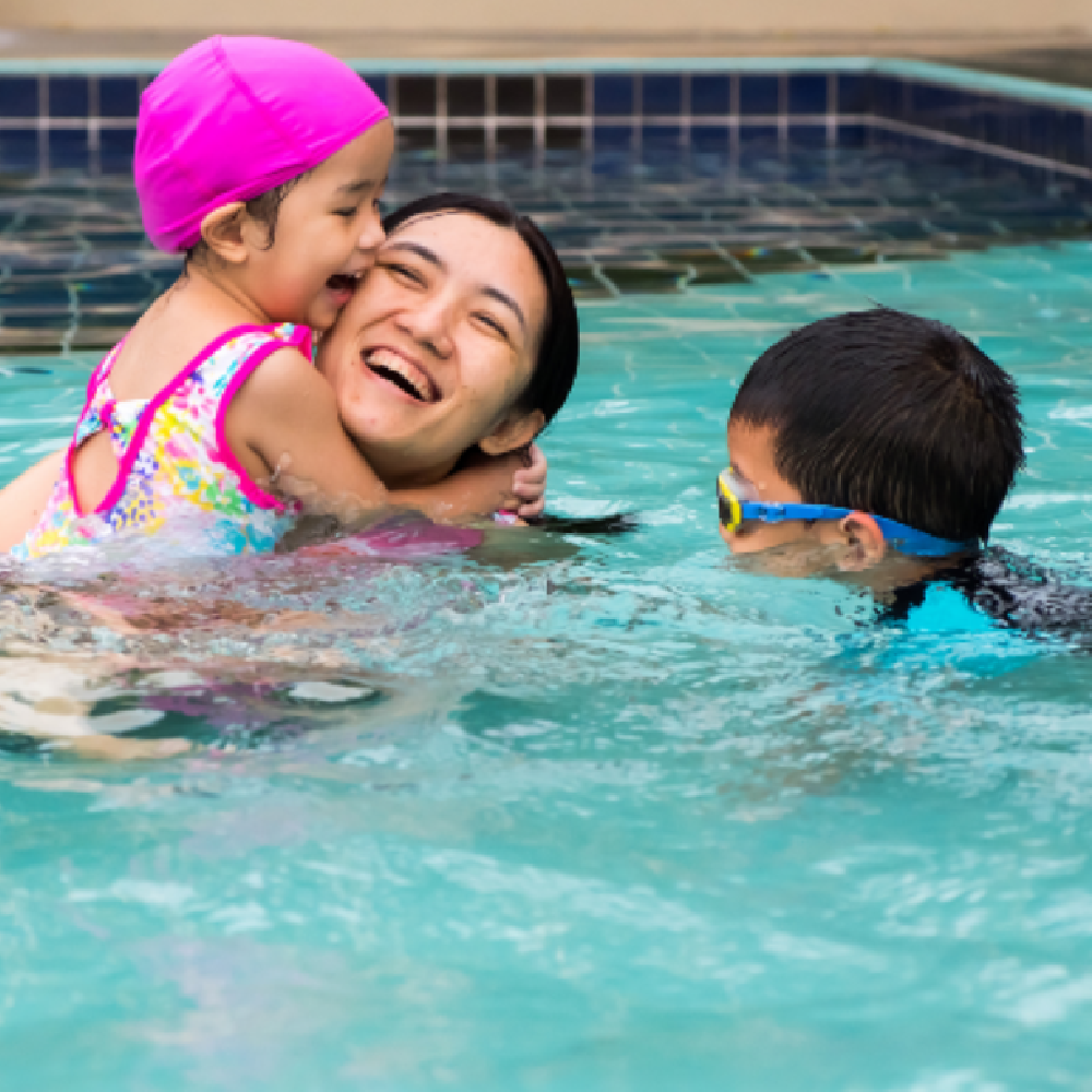 Young mom swimming with her two children