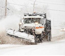 A snowplow clearing roads during a blizzard