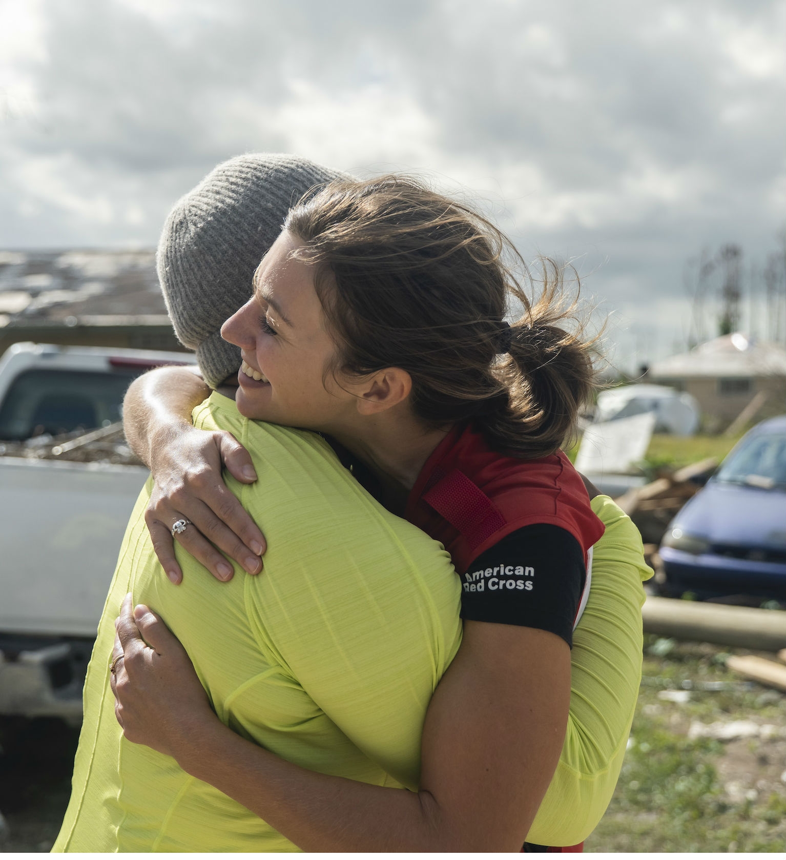 Red Cross volunteer hugging another person.