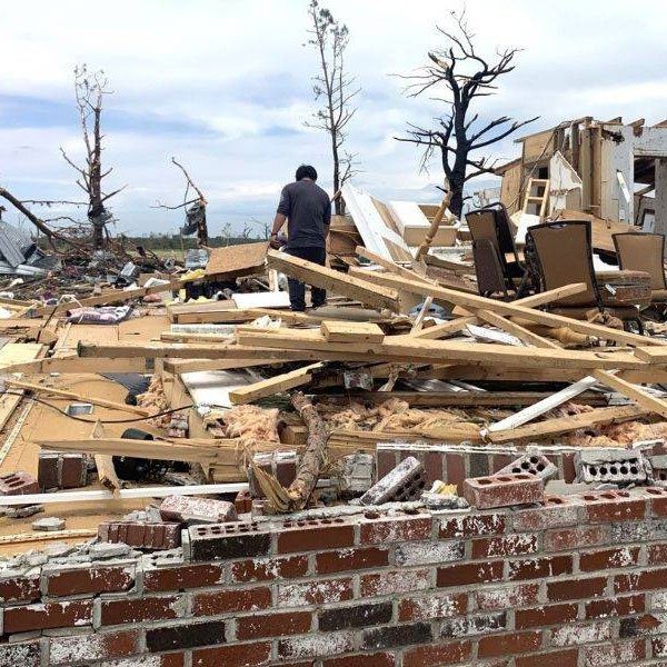 Person searching through rubble and debris, caused by a tornado.