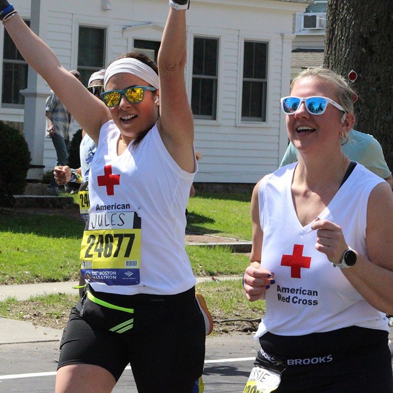 Two Team Red Cross runners running the 2024 Boston Marathon.