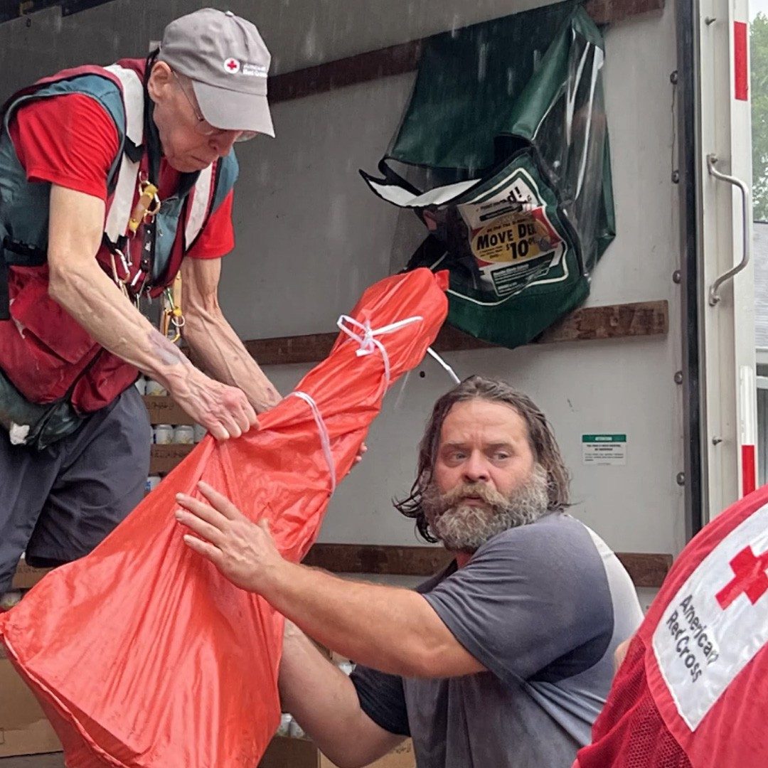 Red cross volunteers unload supplies.