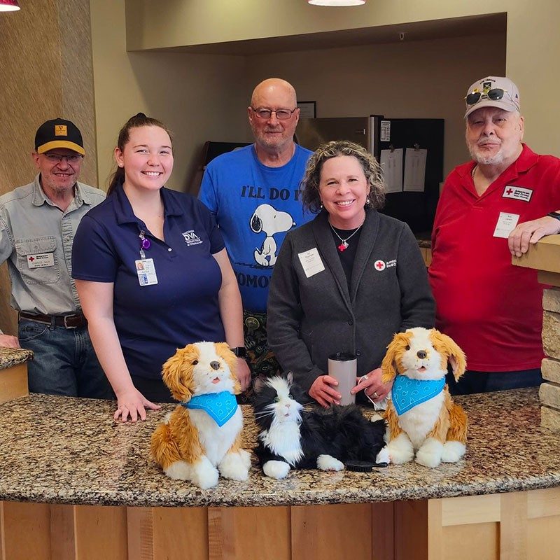 Group photo of Members of the Board of Directors for the American Red Cross Southwest Wisconsin Chapter with robotic therapy dogs and cats.