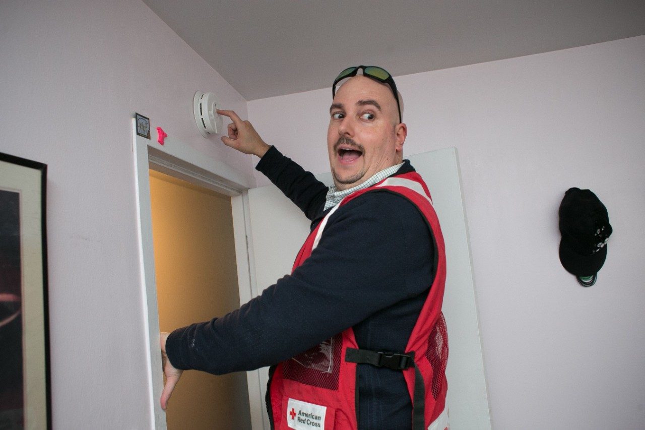volunteer installing smoke alarm