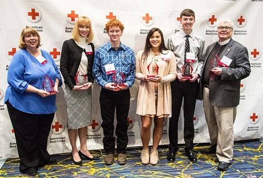 Group photo of Red Cross heroes holding their Red Cross heroes awards.