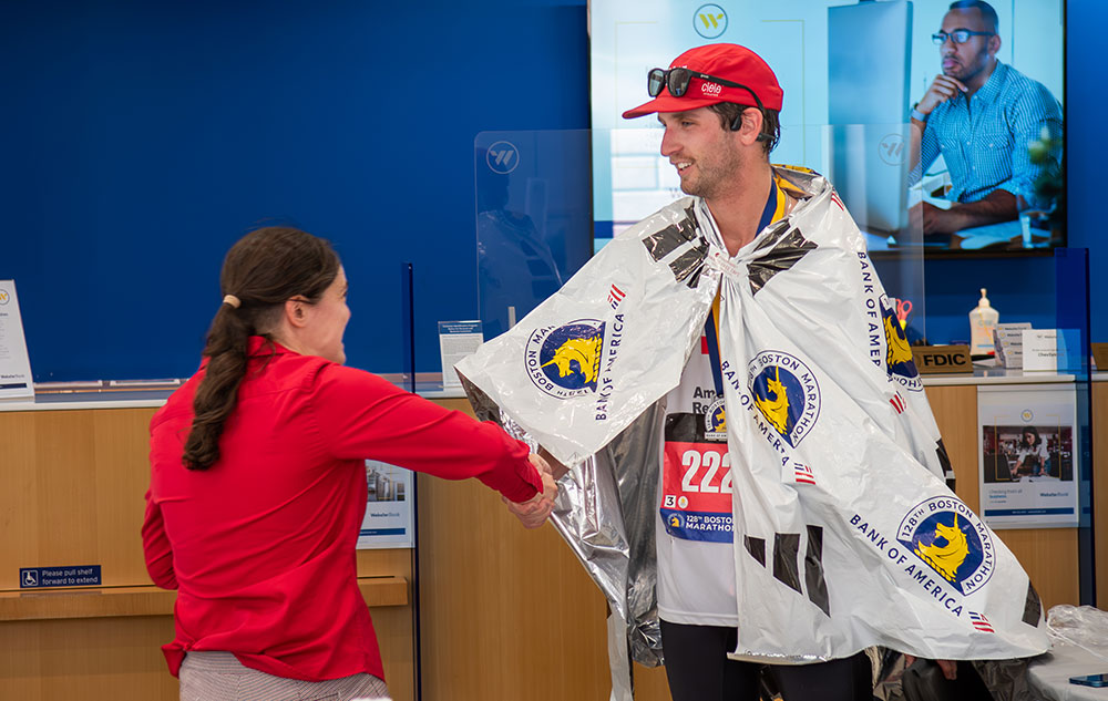 Marathon runner shaking hands with another person.