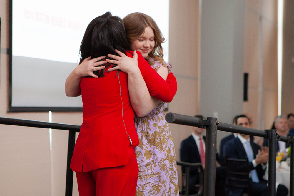 Good samaritan Allie Benkart hugging woman on stage