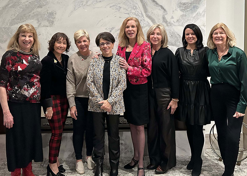 tiffany circle members group photo with marble wall in the background.
