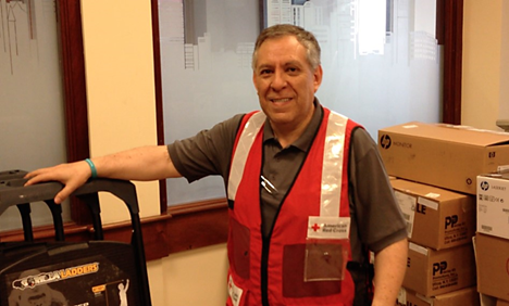 Red Cross volunteer Eduardo Sagarnaga wearing Red Cross vest and smiling for camera.