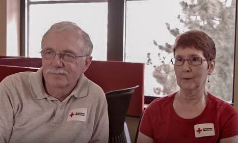 Ron and June Beckley wearing glasses and American Red Cross patches on their shirts.