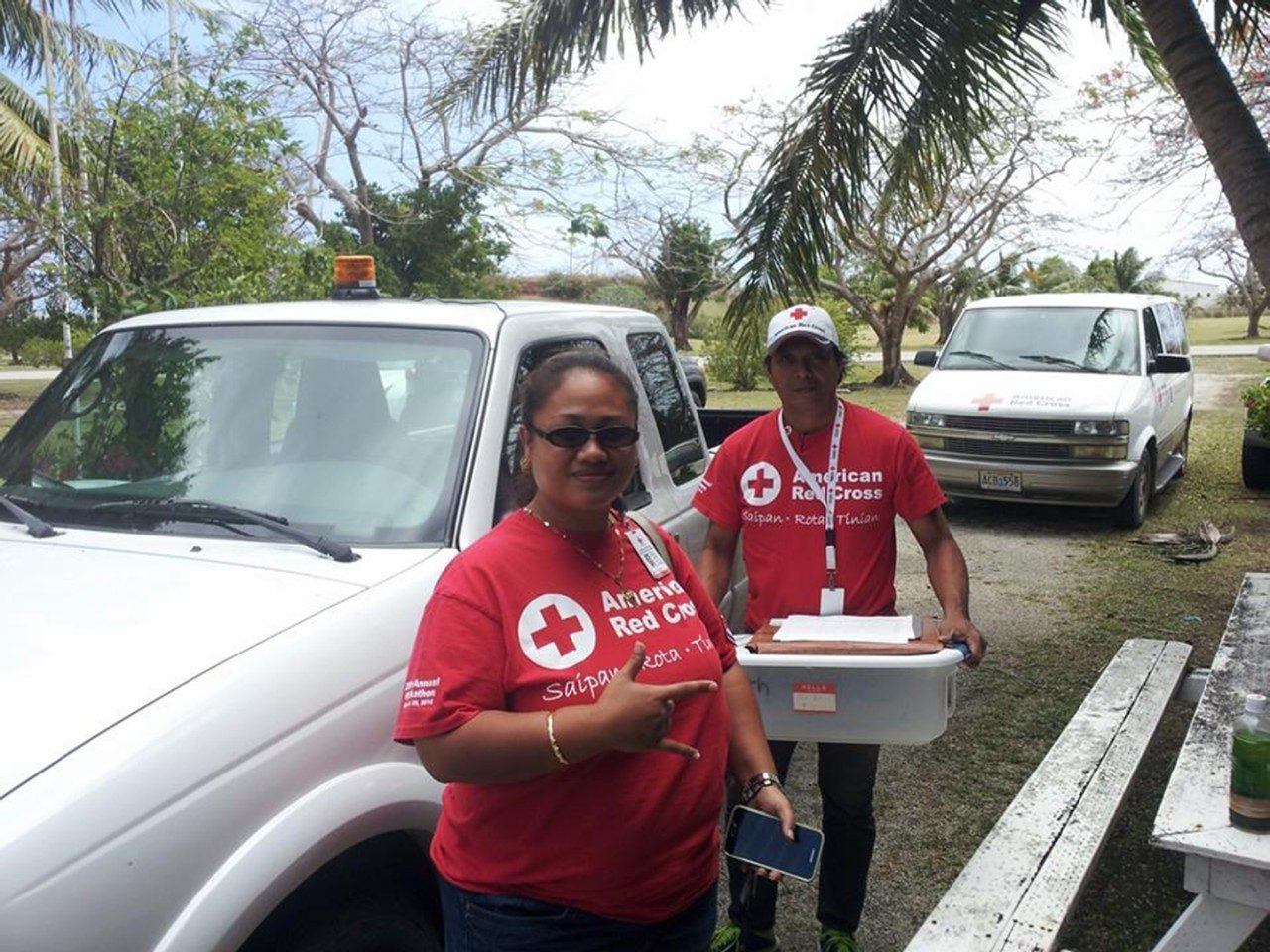 Two Red Cross volunteers next to truck smiling for camera.