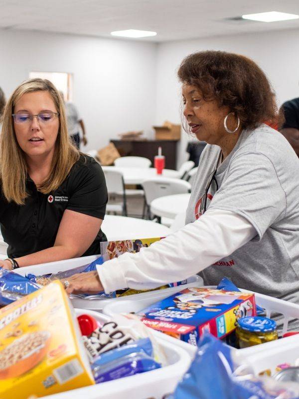 red cross volunteers stocking baskets
