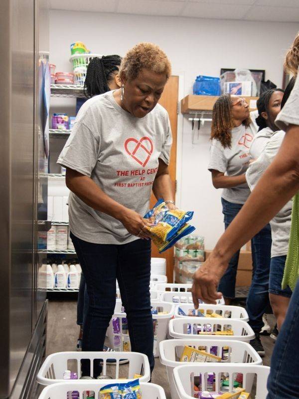 volunteer stocking baskets of food