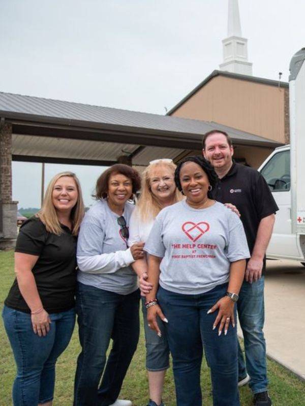 group of volunteers standing in front of community center