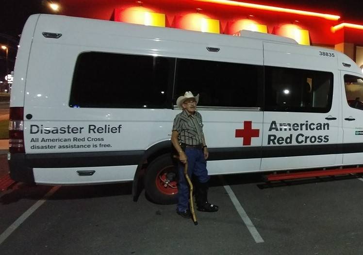 Tom Shands standing in front of red cross emergency vehicle.
