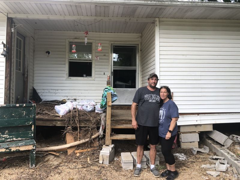 joseph and dana in front of damaged home