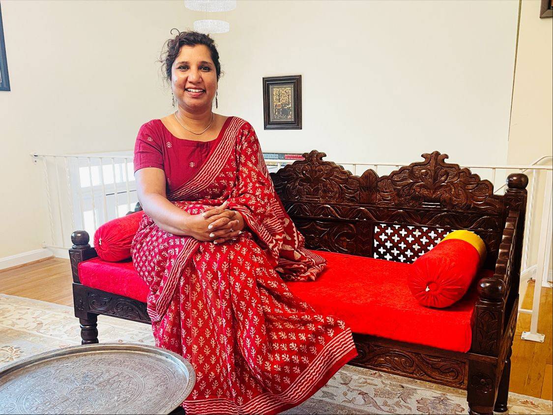 Anjana Dayal de Prewitt sitting on a bench.