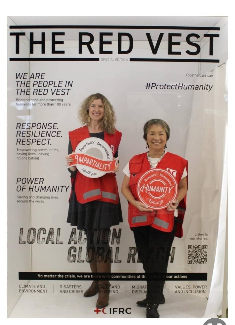 Nicole and another volunteer pose in Red Cross vests for a mock "The Red Vest" magazine cover.