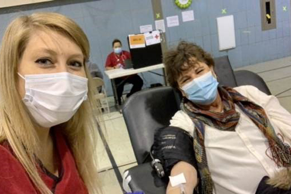 Eileen Perra in a chair donating blood.
