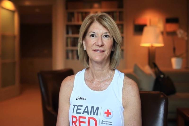 Karen Teller sitting in a chair in her office wearing a Team Red shirt.
