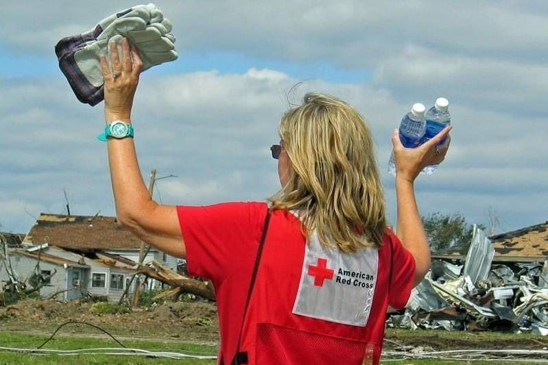 Sherri Odell holding gloves and water bottles outside.