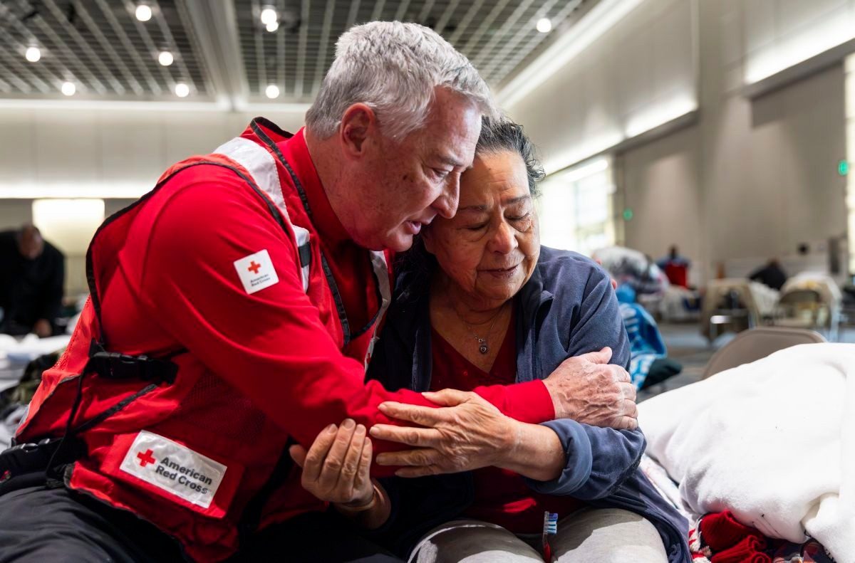 Red Cross Disaster Relief volunteer comforts Alice Galicia at a shelter in California, after she was forced to evacuate due to the wildfires.