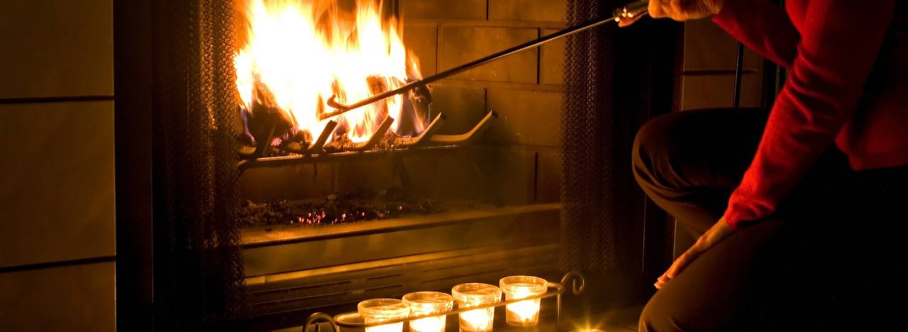 Person stoking a fire with a fire poker